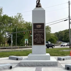 bronze memorial of flame on a pedestal with bronze plaque