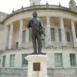 Bronze monument of life size man in front of captiol building