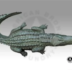 small bronze sculpture of a alligator with a dark green patina
